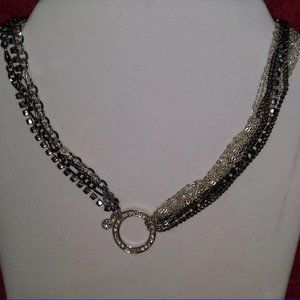 Silver tone necklace with black and crystal links.